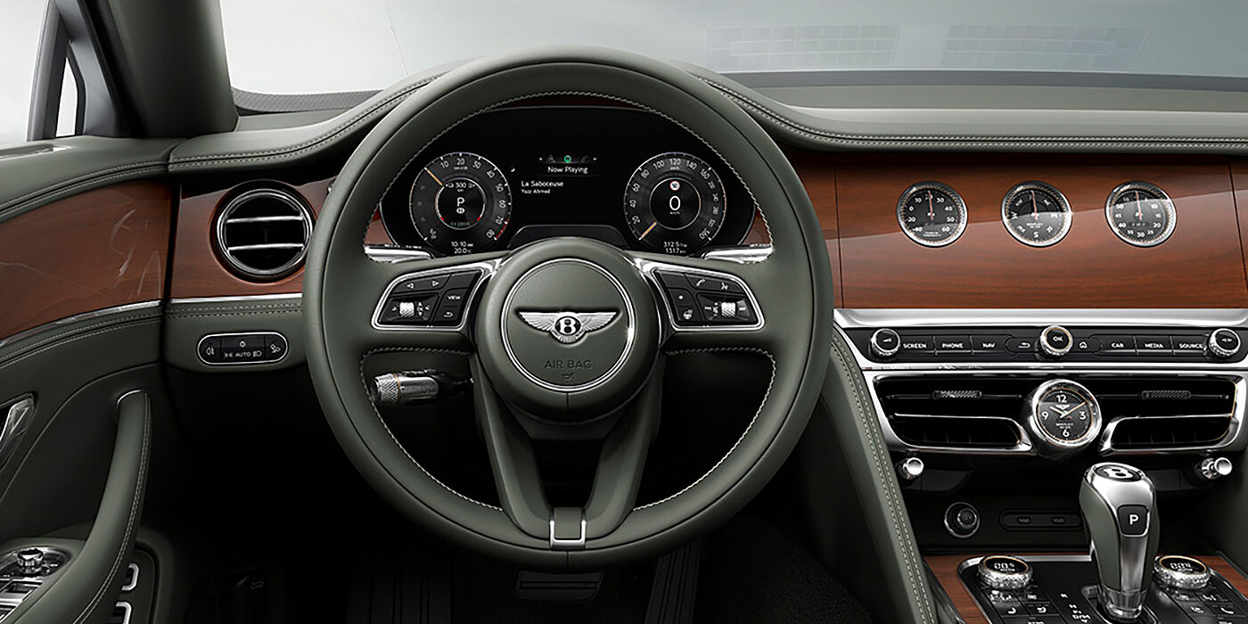 Bentley Johannesburg New Bentley Flying Spur sedan front cabin in Cumbrian Green hide and Crown Cut walnut veneer showing steering wheel and Rotating Display with three clocks on face