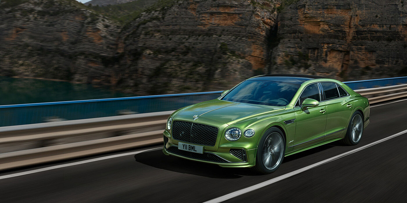 Bentley Johannesburg Bentley New Flying Spur Speed v8 hybrid sedan driving dynamically on a mountain road in Tourmaline Green paint