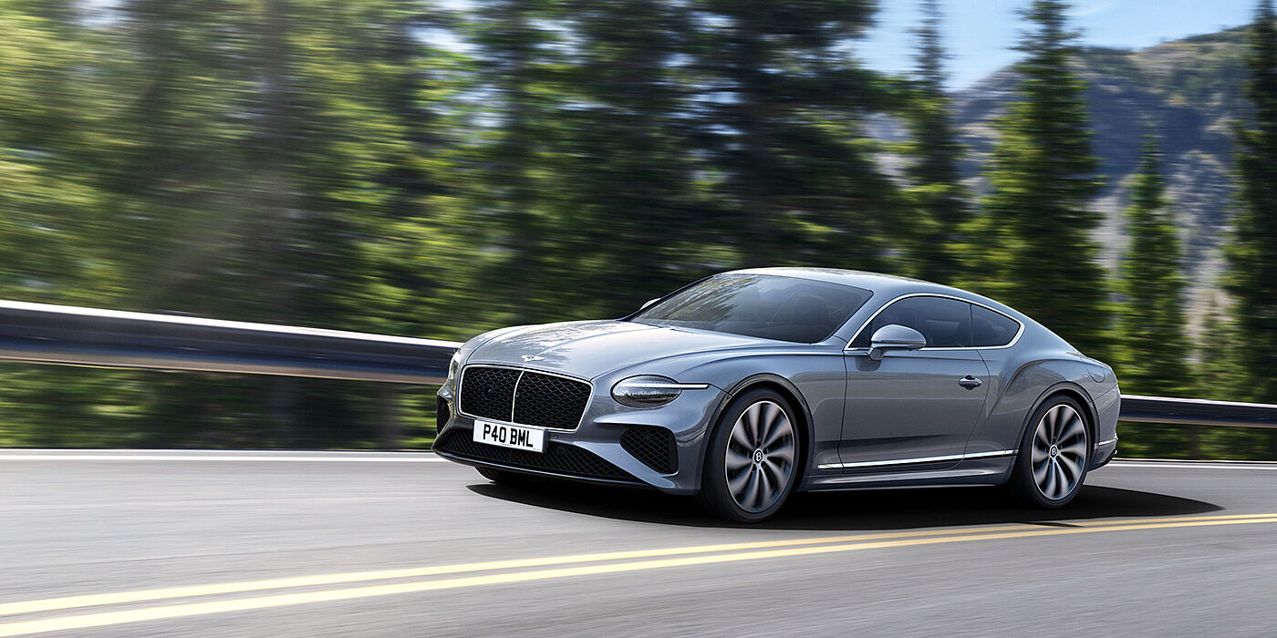 Bentley Johannesburg New Bentley Continental GT coupe in Silverlake paint and 22 inch ten-spoke wheels, driving dynamically on a tree-lined road in the sunshine