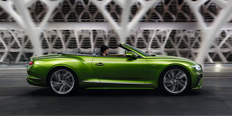 Bentley Johannesburg Bentley Continental GTC Speed convertible side profile in Tourmaline Green paint driving dynamically on a bridge at night