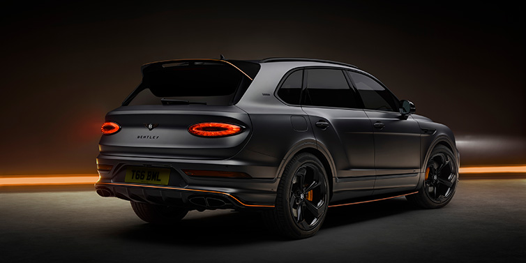 Bentley Johannesburg Bentley Bentayga S Black Edition SUV rear three quarter in Anthracite Satin paint against a dark red and yellow background