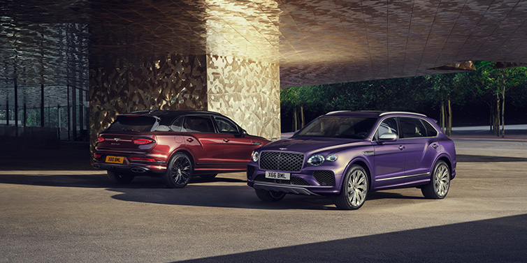 Bentley Johannesburg A duo of Bentley Bentayga Extended Wheelbase Mulliner SUVs parked in a city environment, with Tanzanite Purple and Cricket Ball red exterior paint